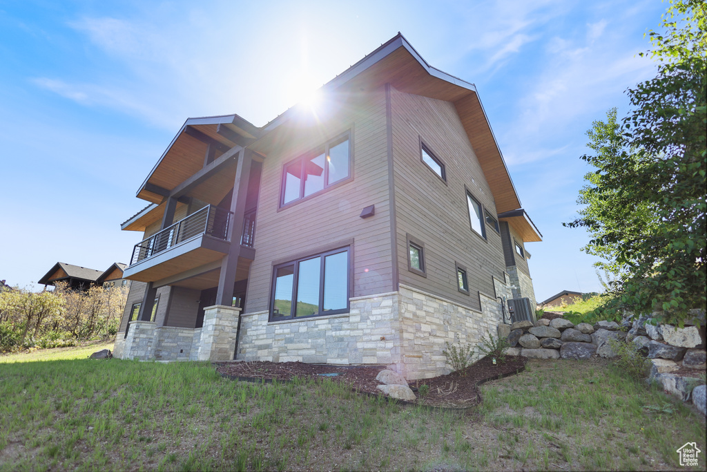 View of property exterior with a balcony and stone siding