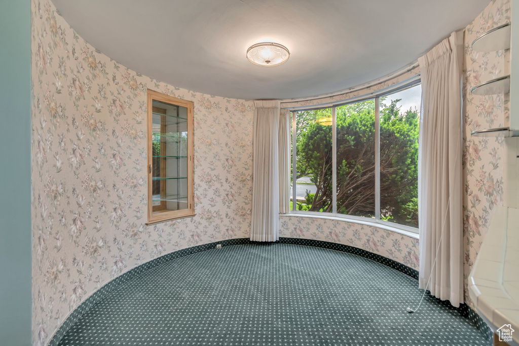 Carpeted spare room featuring wallpapered walls