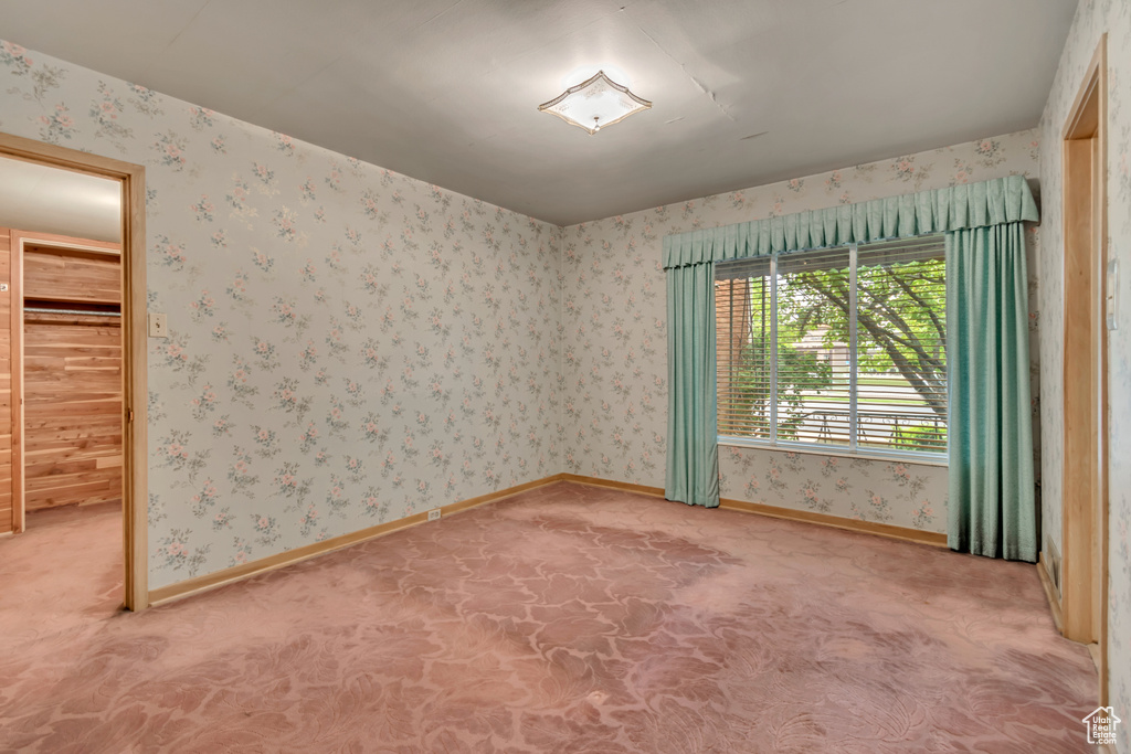 Carpeted empty room featuring baseboards