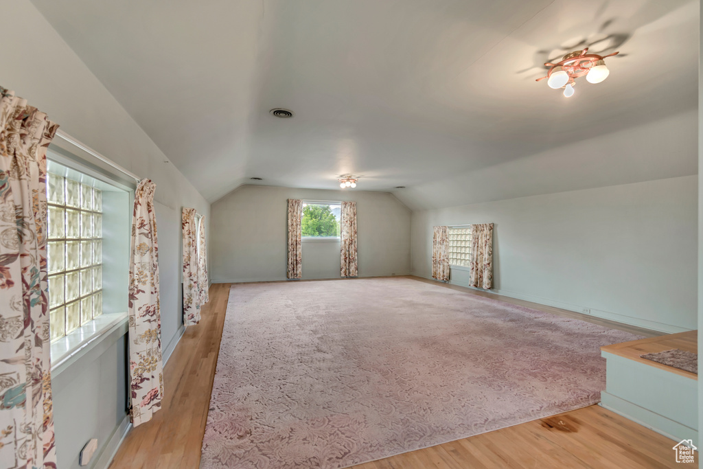 Bonus room featuring lofted ceiling, wood finished floors, and baseboards