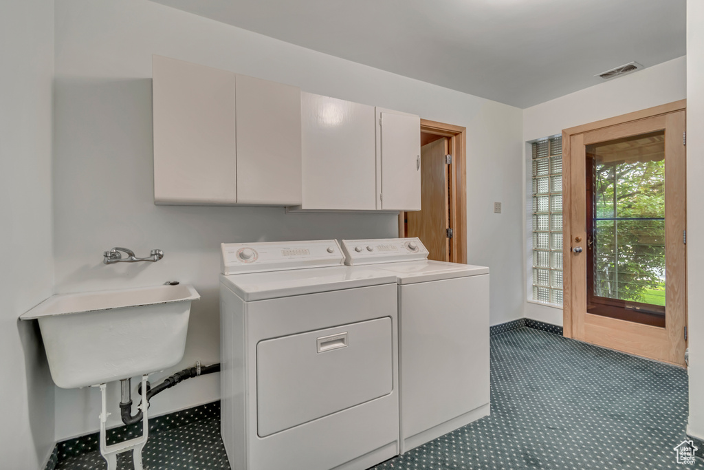 Laundry room with carpet, cabinet space, and washer and dryer