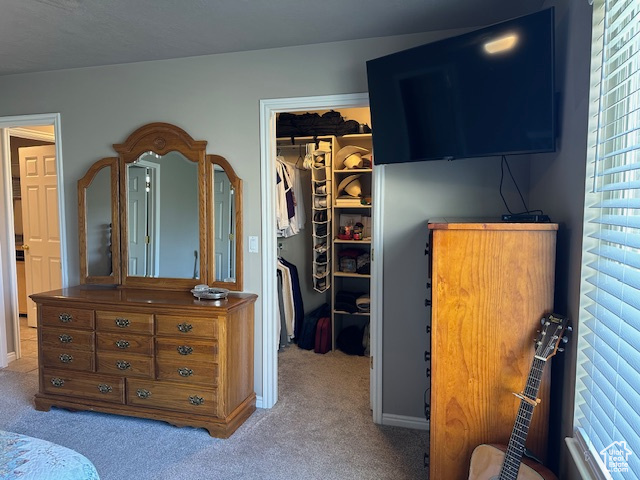 Bedroom with a walk in closet, carpet, and a closet