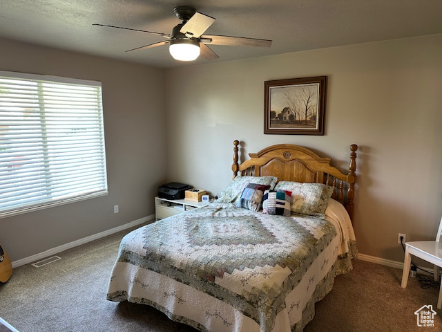 Bedroom with carpet flooring, baseboards, and a ceiling fan