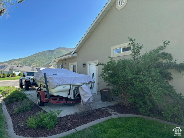 View of side of property featuring stucco siding and a mountain view
