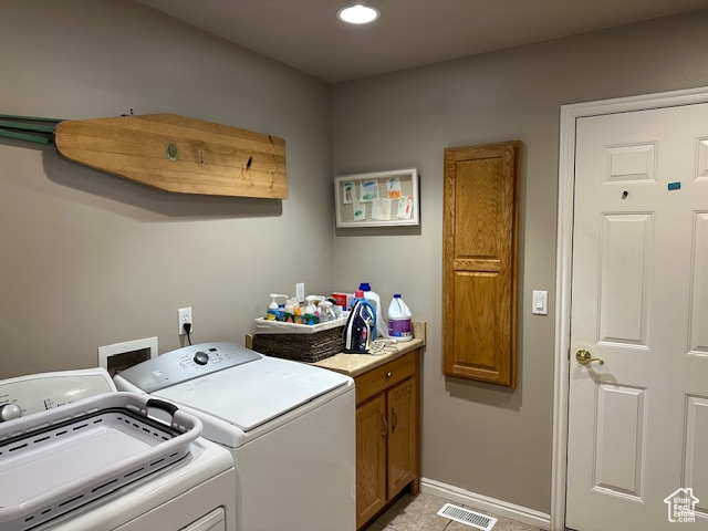 Laundry area with separate washer and dryer, cabinet space, recessed lighting, and baseboards