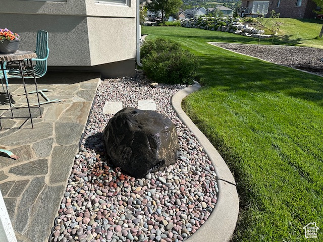 View of green lawn featuring a patio area