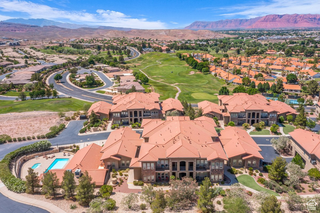 Aerial perspective of suburban area with a mountain backdrop and a golf course