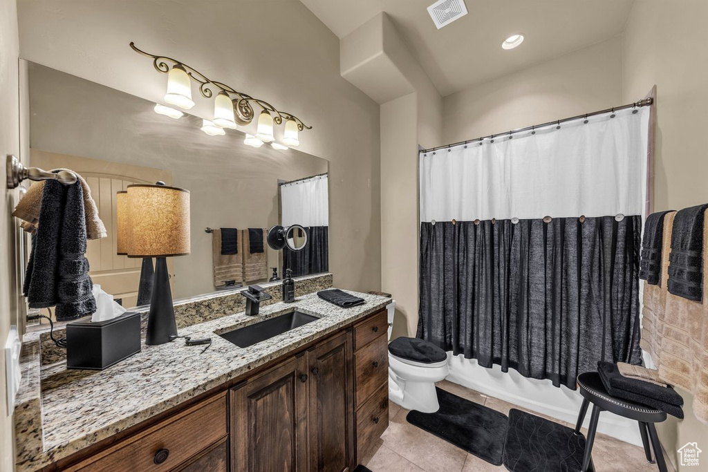 Full bath featuring vanity, toilet, tile patterned floors, and shower / tub combo