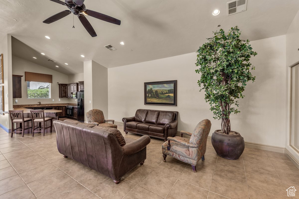 Living area featuring light tile patterned flooring, lofted ceiling, recessed lighting, and a ceiling fan