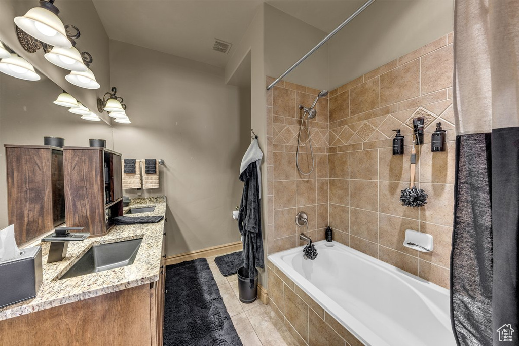 Full bathroom with tiled shower / bath, double vanity, and tile patterned flooring