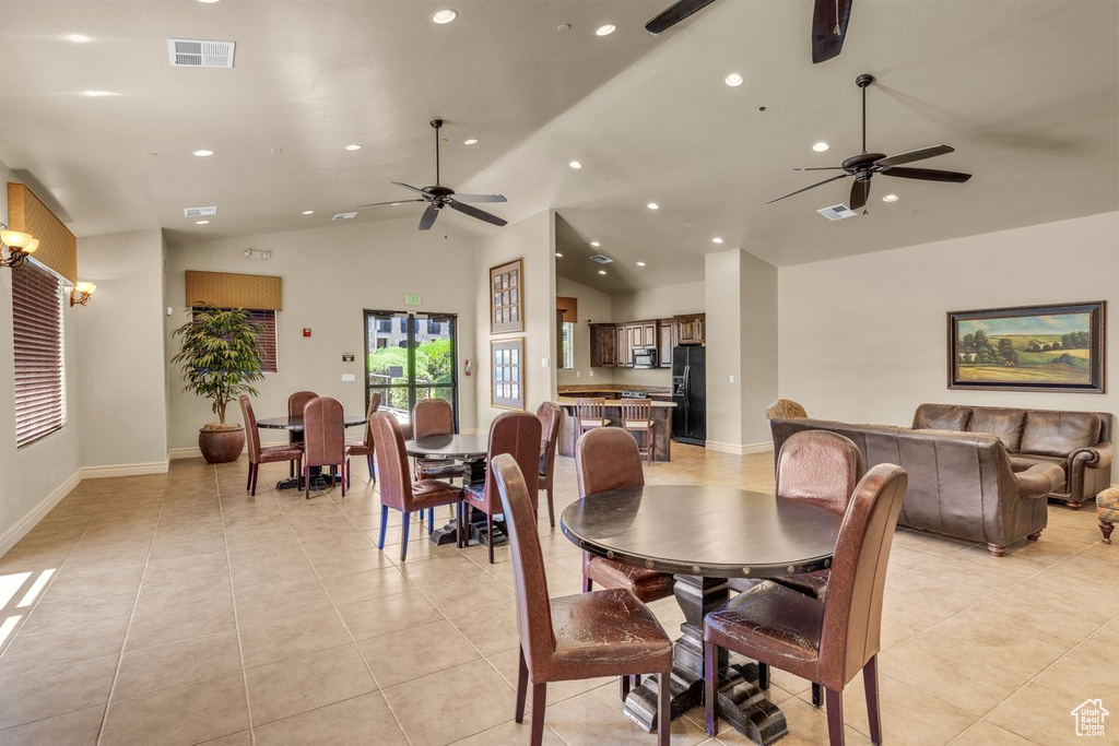 Dining area with ceiling fan, recessed lighting, light tile patterned floors, vaulted ceiling, and baseboards