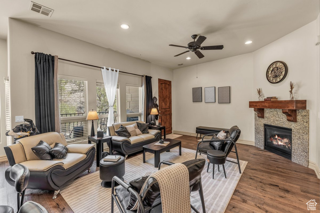 Living area featuring ceiling fan, a glass covered fireplace, recessed lighting, wood finished floors, and baseboards