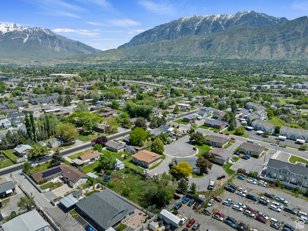 Aerial view of property and surrounding area with a mountain backdrop and nearby suburban area