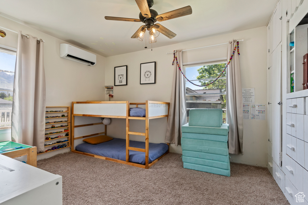 Bedroom featuring carpet floors, an AC wall unit, and ceiling fan