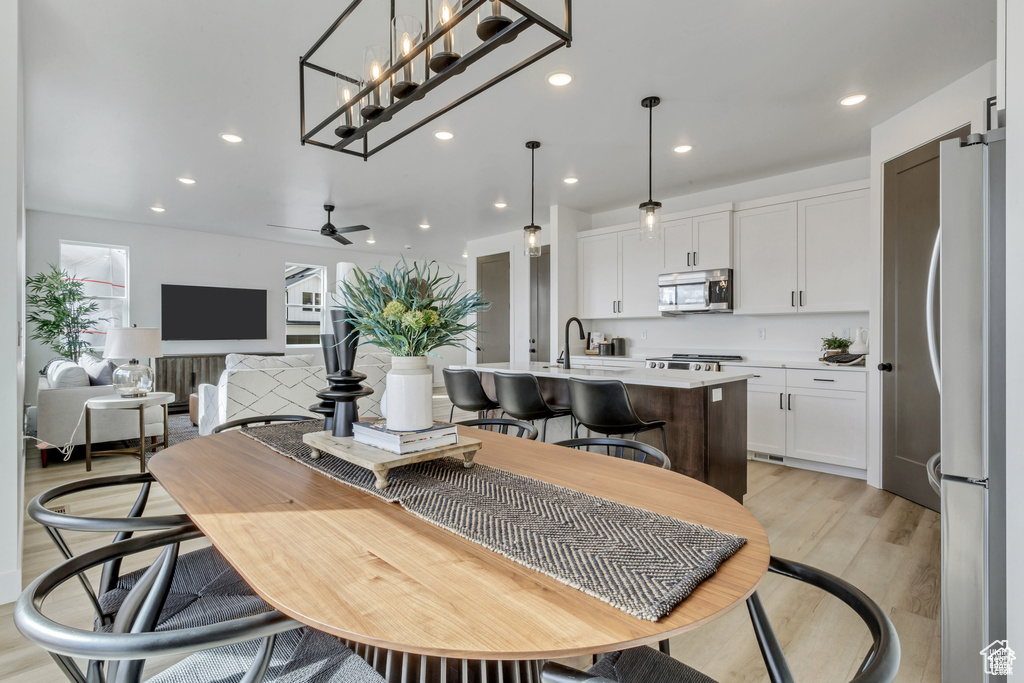 Dining room with light wood finished floors, recessed lighting, and ceiling fan