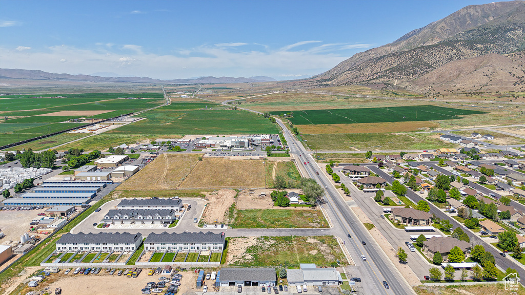 Aerial view of property and surrounding area featuring a mountain backdrop