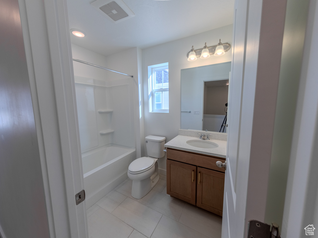 Bathroom with vanity, tile patterned floors, toilet, shower / bathtub combination, and baseboards