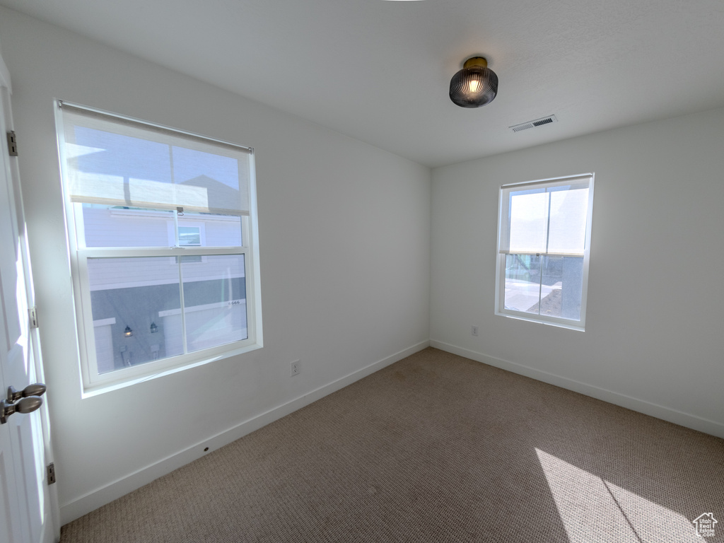 Carpeted empty room with baseboards