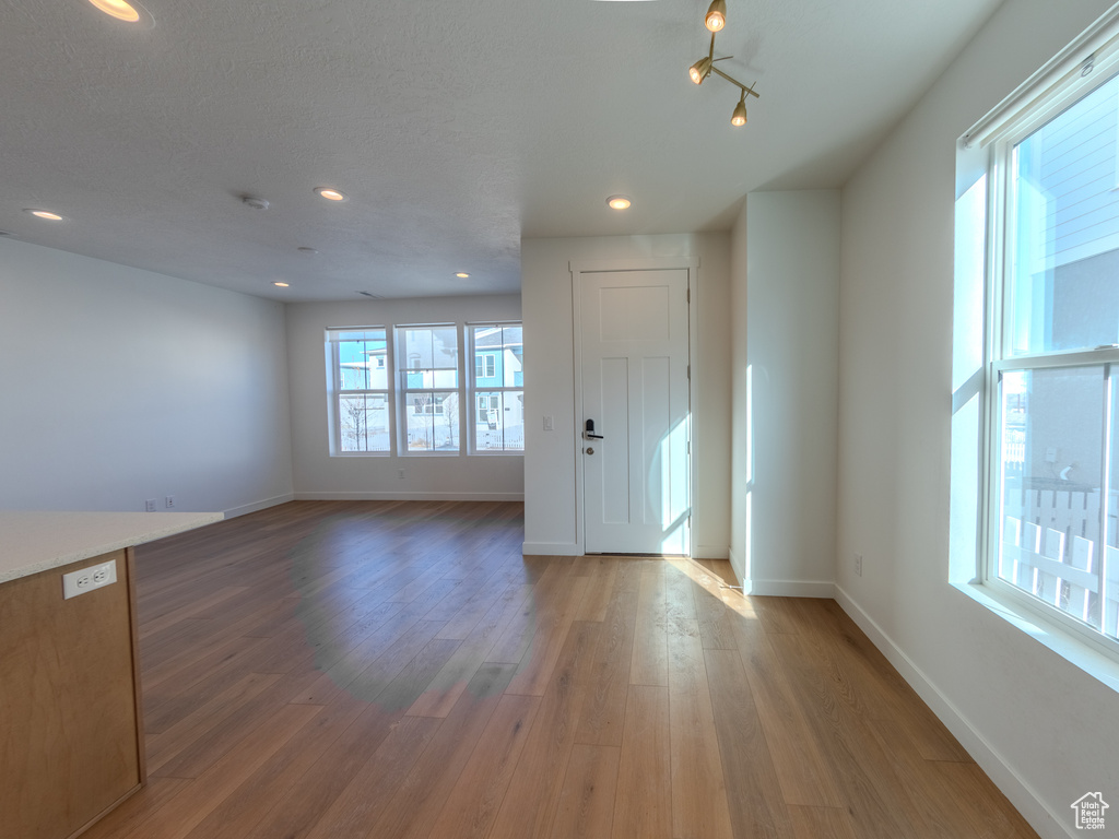 Unfurnished living room featuring wood finished floors, baseboards, and recessed lighting