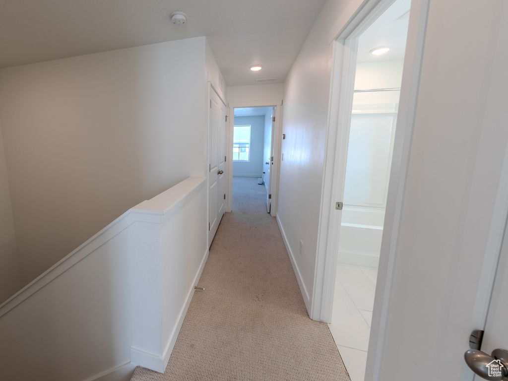 Hall with light colored carpet and recessed lighting