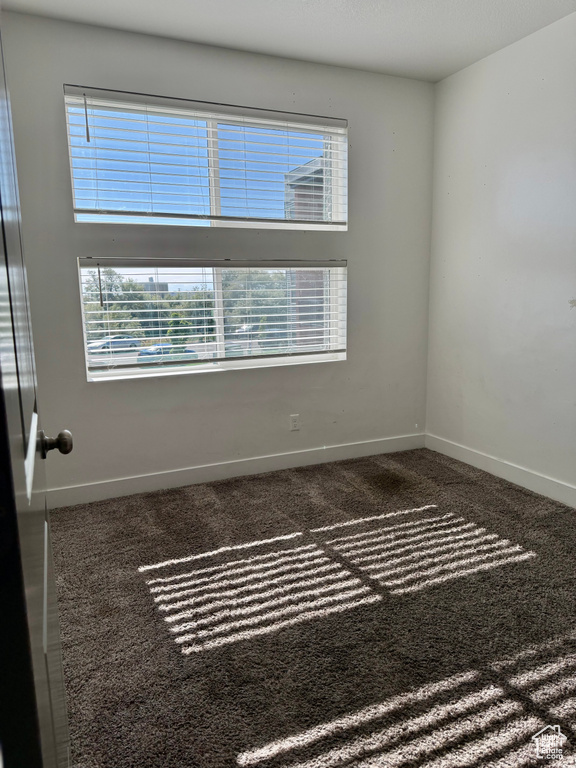 Spare room featuring baseboards and carpet