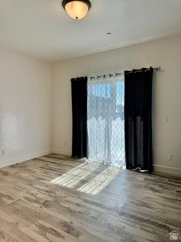 Unfurnished room featuring wood finished floors and baseboards