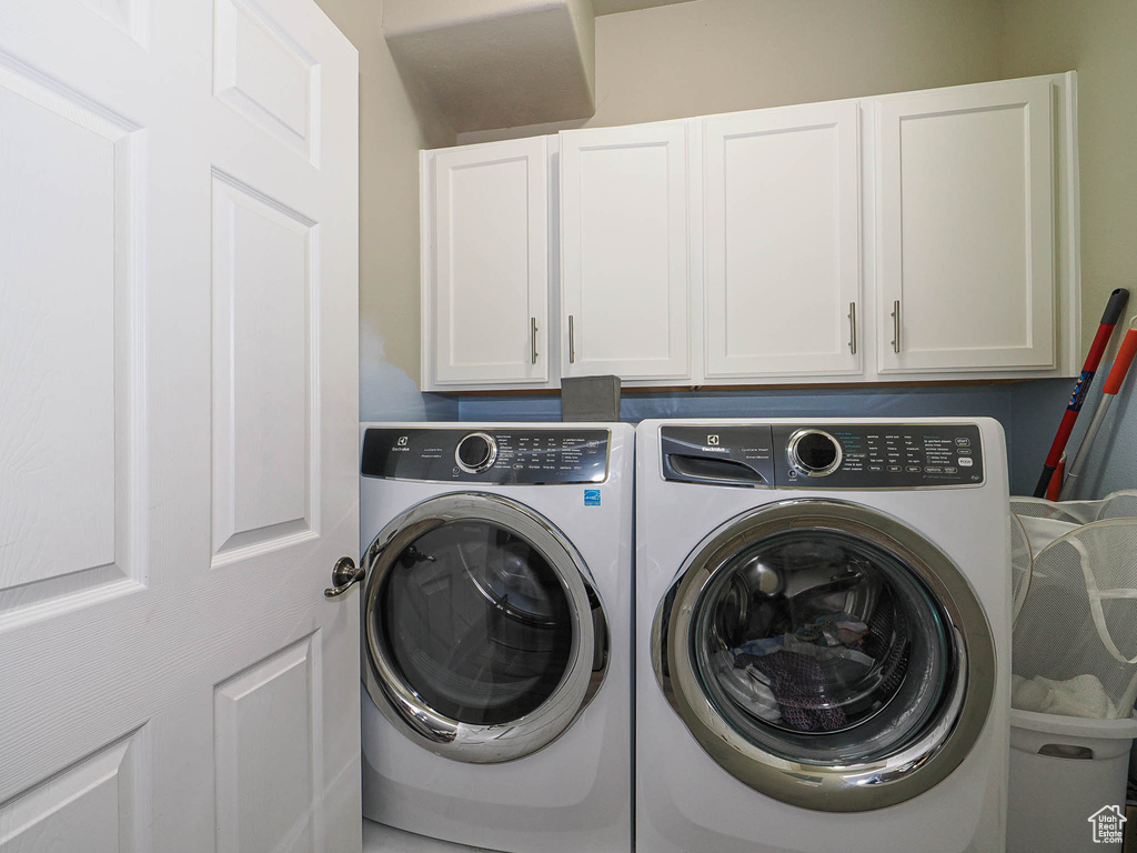 Laundry room featuring cabinet space and independent washer and dryer