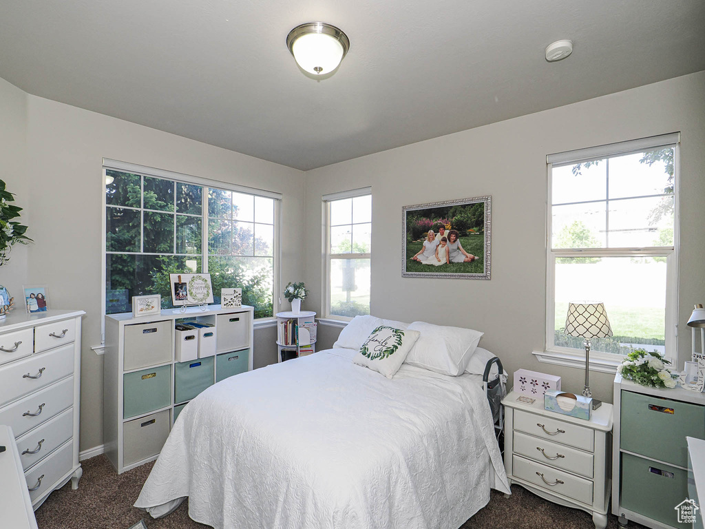 Bedroom featuring dark colored carpet and baseboards