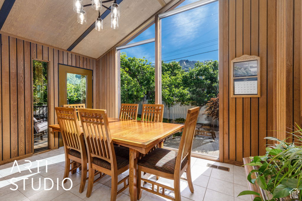 Sunroom featuring lofted ceiling, a chandelier, and a mountain view