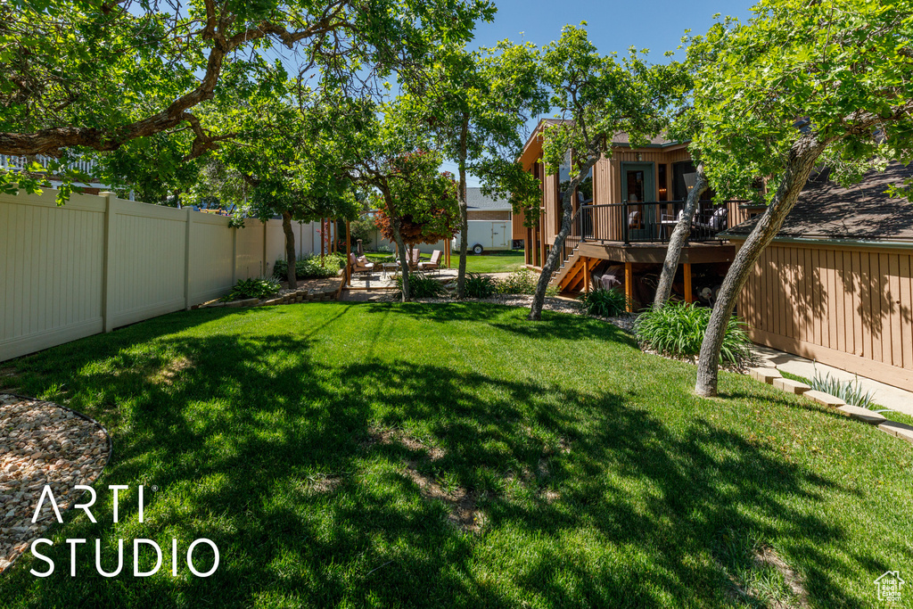 View of yard featuring a wooden deck and stairway