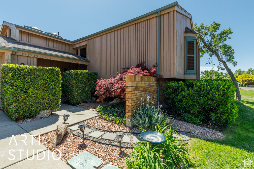 View of side of home with a yard