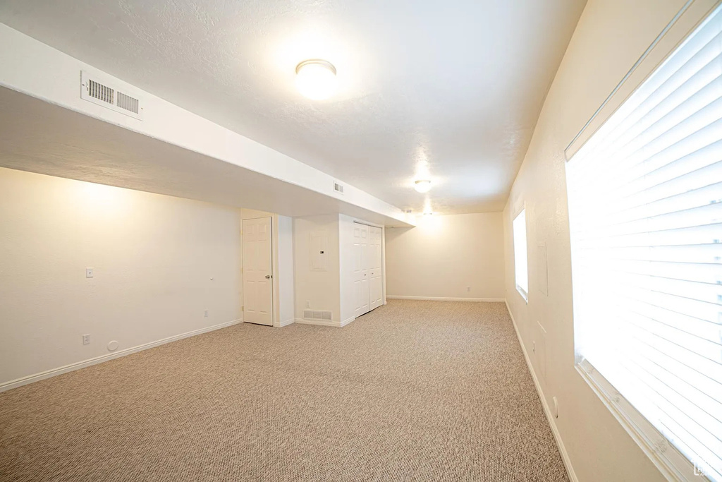 Basement with light colored carpet and baseboards