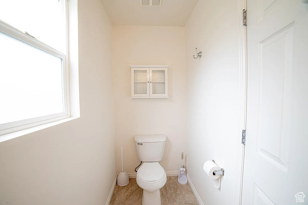 Bathroom with toilet, baseboards, and tile patterned flooring
