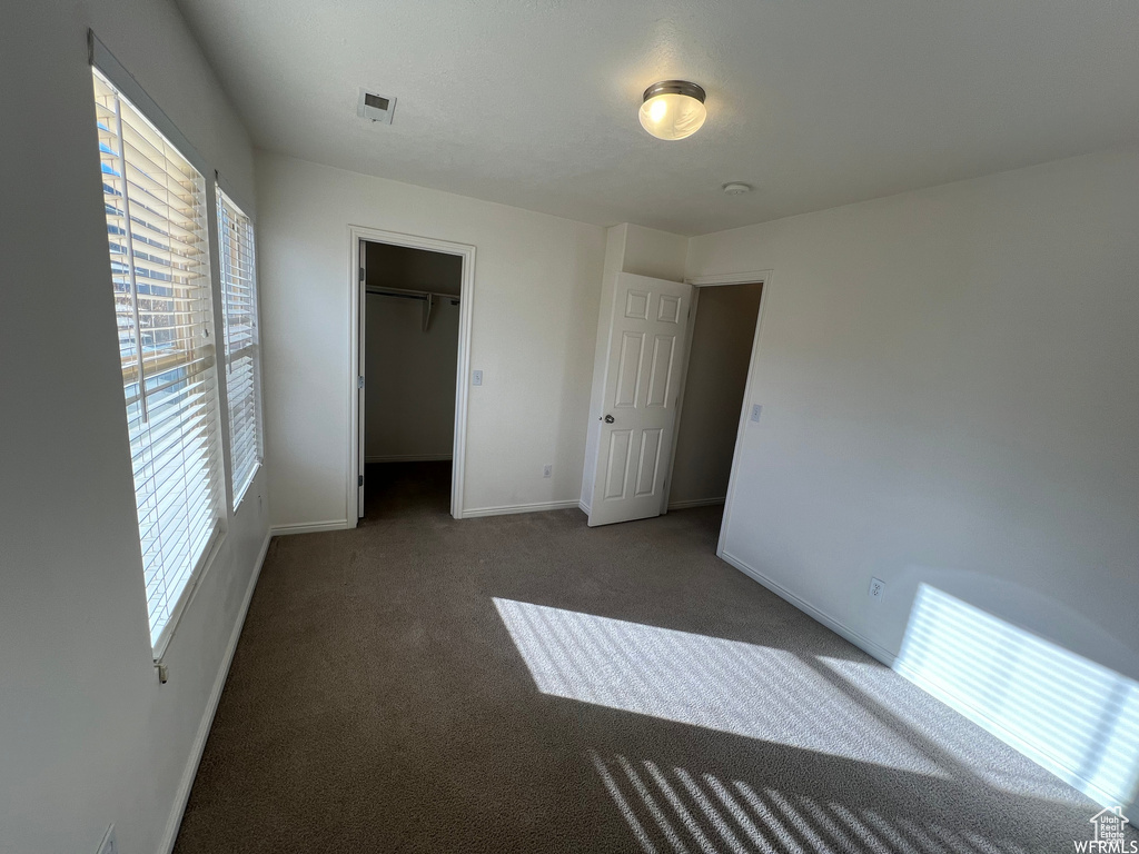 Unfurnished bedroom with carpet flooring and baseboards
