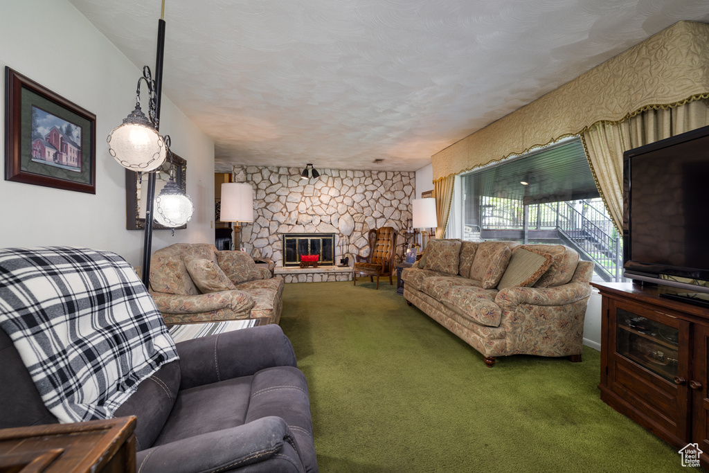 Living room featuring carpet floors and a stone fireplace