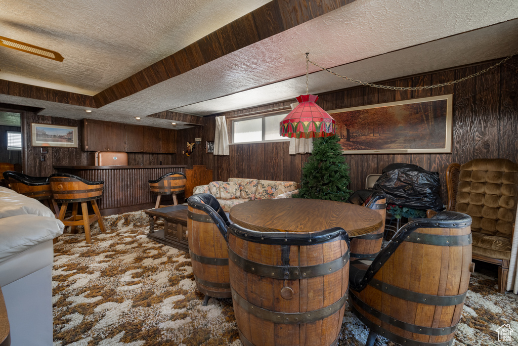 Dining space featuring wood walls and a textured ceiling