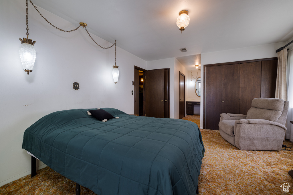 Bedroom with carpet, multiple closets, and connected bathroom