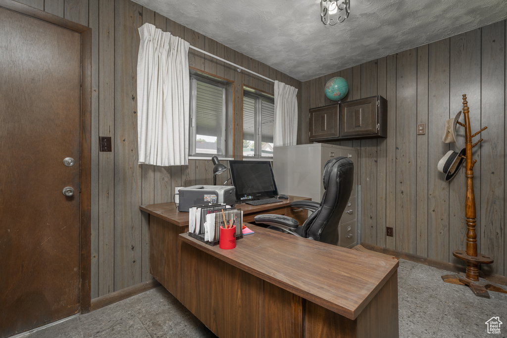 Office area featuring wooden walls and baseboards