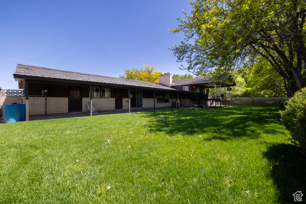 Rear view of property with a chimney and a patio area