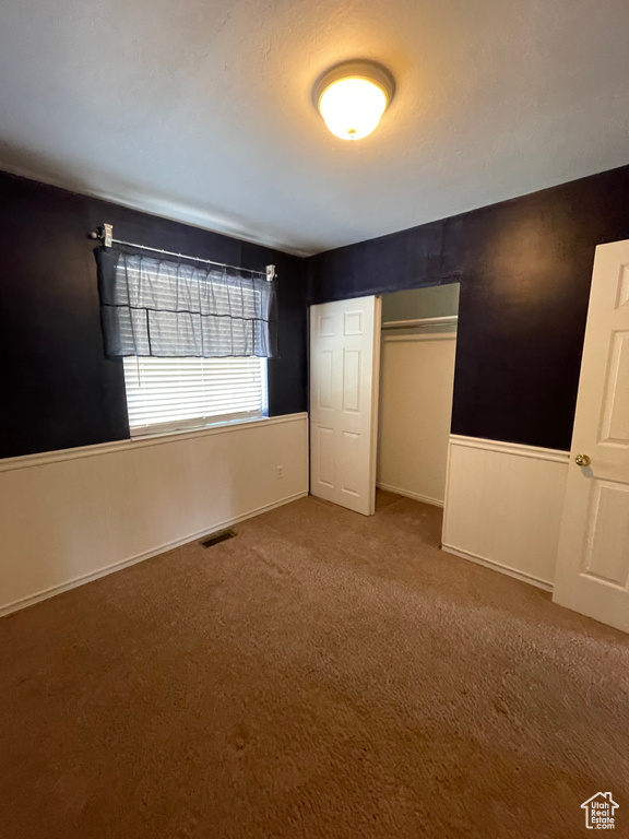 Unfurnished bedroom featuring carpet floors and a closet