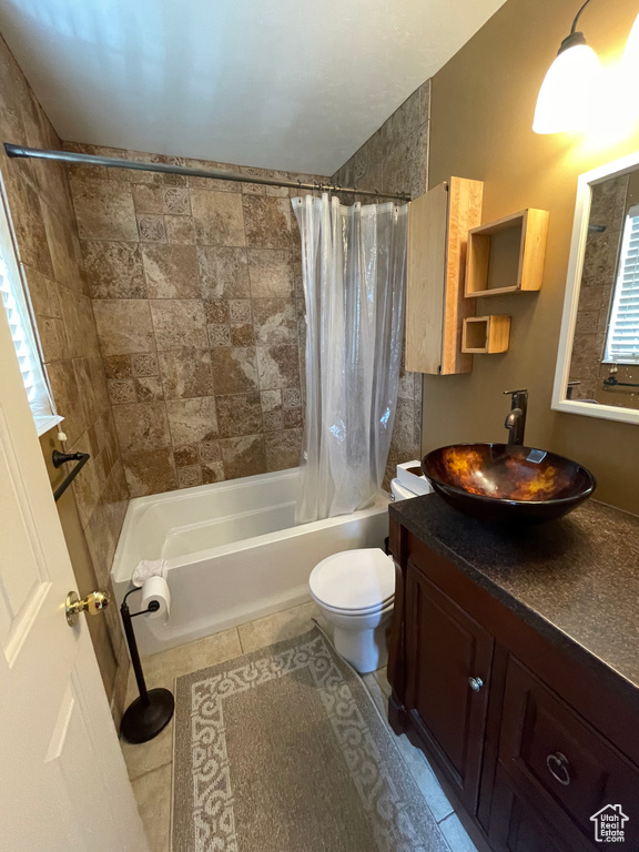 Bathroom featuring shower / tub combo with curtain, toilet, vanity, and tile patterned flooring