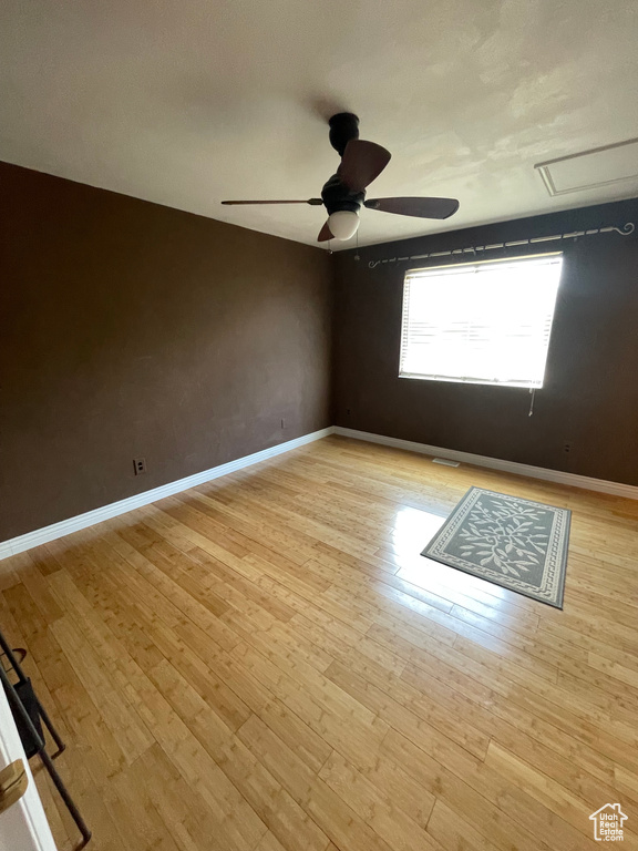 Unfurnished room featuring ceiling fan, light wood-type flooring, and baseboards