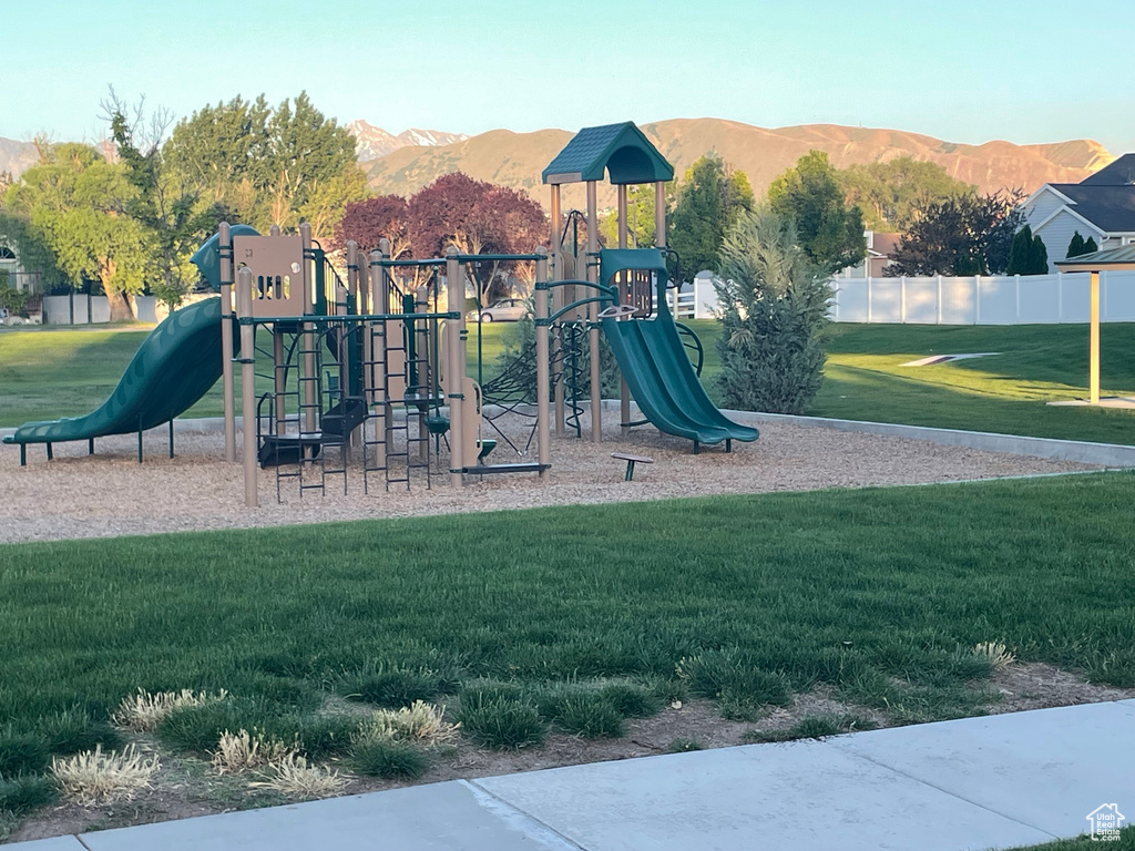 Communal playground with a mountain view and a lawn