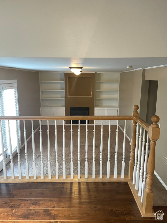 Staircase featuring hardwood / wood-style flooring, a fireplace, and baseboards