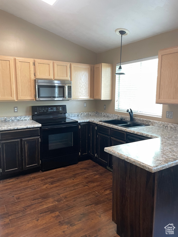 Kitchen with stainless steel microwave, black / electric stove, a sink, light brown cabinets, and lofted ceiling