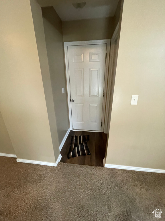 Hallway featuring baseboards and carpet