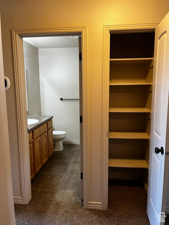 Bathroom with vanity, toilet, and baseboards