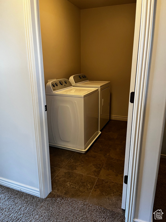 Washroom with washing machine and clothes dryer and baseboards