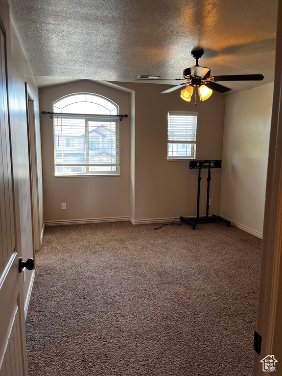 Spare room with carpet floors, ceiling fan, a textured ceiling, and baseboards