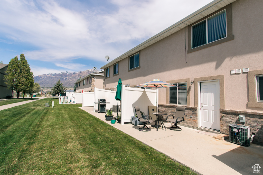 Rear view of house featuring a mountain view, cooling unit, stucco siding, a patio area, and stone siding